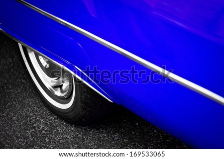 Detail of the back wheel of a vintage blue car