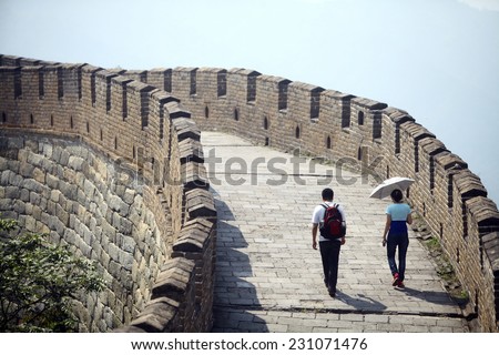 Mutianyu, China - September 19, 2014: Color horizontal shot of two persons walking The Great Wall of China, at Mutianyu.