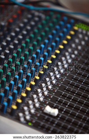 Detail of a music mixer desk with various knobs.
