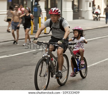NEW YORK - AUGUST 04: Unidentified mom with daughter rides bicycle along Park Avenue during Summer Streets sponsored by Department of Transportation in Manhattan on August 4, 2012 in New York