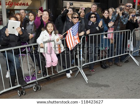 NEW YORK - NOVEMBER 11: People wave to veterans and active duty military at Veteran\'s Day Parade along 5th Avenue on November 11, 2012 in New York City