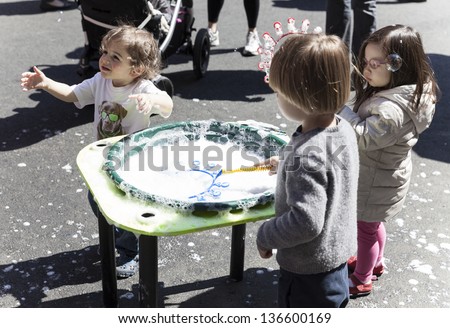 NEW YORK - APRIL 27: Unidentified kids play with soap bubbles at Family festival during the 2013 Tribeca Film festival on Greenwich street on April 27, 2013 in New York City