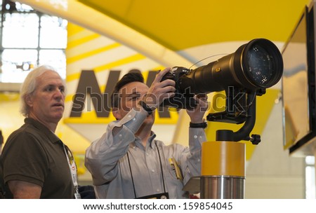 NEW YORK - OCTOBER 24: Representative of Nikon shows off telephoto lens at Photoplus expo organized by Photo District News at Javits Convention Center on October 24, 2013 in New York City