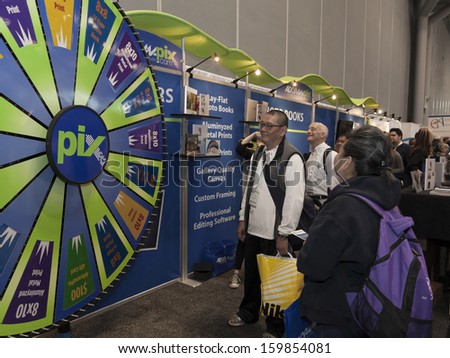 NEW YORK - OCTOBER 24: Unidentified attendies participate in prize drawing at AdoramaPix booth at Photoplus expo organized by Photo District News at Javits Convention Center on October 24, 2013 in NYC