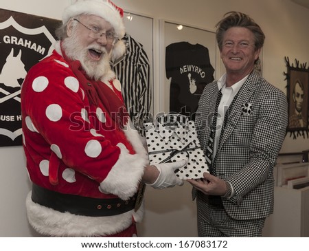 NEW YORK - DECEMBER 12: Designer Nick Graham and Santa Claus show designer shirt at Nick Graham pop-up shop at the Paul Kasmin Store in Chelsea on December 10, 2013 in New York City.