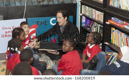 NEW YORK - DECEMBER 20: Adrien Brody reads book during Post-Sandy Holiday Party at The Action Center presented by Bulgari & Save the Children on Dec 20, 2013 in Far Rockaway of Queens in NYC