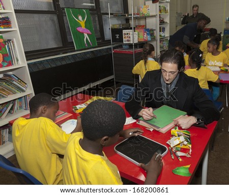 NEW YORK - DECEMBER 20: Adrien Brody draws with kids during Post-Sandy Holiday Party at The Action Center presented by Bulgari & Save the Children on Dec 20, 2013 in Far Rockaway of Queens in NYC