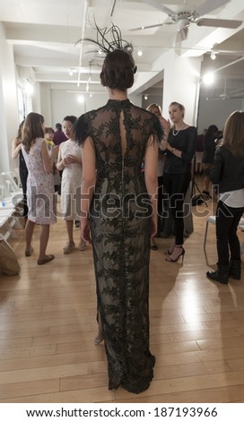 NEW YORK, NY - APRIL 13, 2014: Model shows off evening gown and hat with feathers for Junko Yoshioka runway show during bridal week at Studio Arte on 37th Street