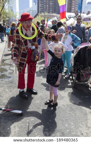 NEW YORK, NY - APRIL 26, 2014: Kids and parents play with clown at Family festival during the 2014 Tribeca Film festival on Greenwich street
