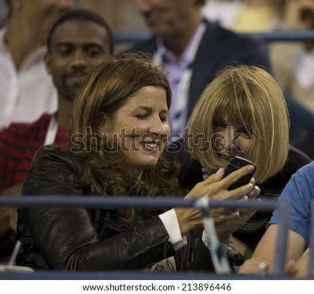 NEW YORK, NY - AUGUST 26: Mirka Federer shares images on smartphone with Anna Wintour at 1st round match between Roger Federer of Switzerland and Marinko Matosevic of Australia at US Open tournament