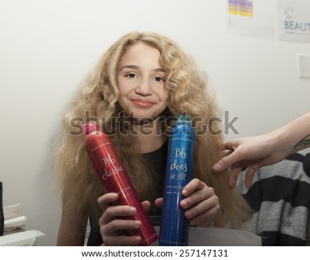 NEW YORK, NY - FEBRUARY 28, 2015: Young model prepares backstage using Bumble and Bumble hair spray during PetiteParade 8th Edition at Bathhouse Studios