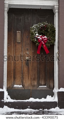 Christmas wreath on the door covered with snow