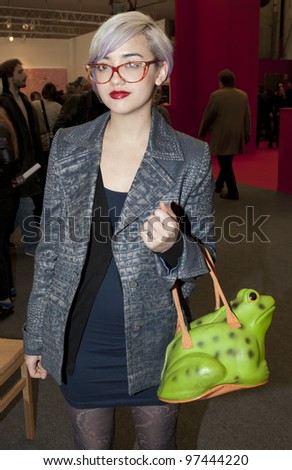 NEW YORK - MARCH 10: Unidentified woman with fancy bag enjoys contemporary art exhibition The Armory Show at Piers 92 & 94 on March 10, 2012 in New York City