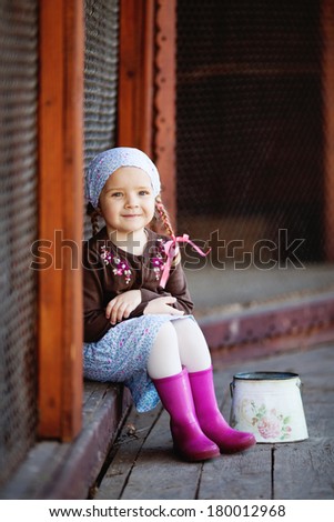 Girl sits next to cells with birds and smiling