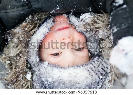 Boy laying on the snow, winter day