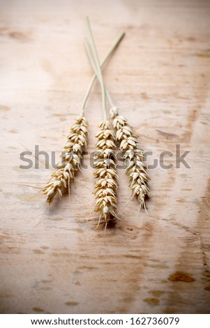Wheat bunch with a menu board, wooden background.
