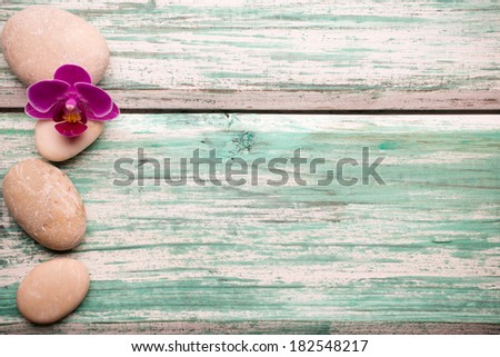 Spa stones on wooden background with orchids.