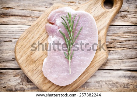 Pork chop, meat slices  on a wood background.