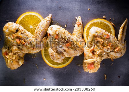 Chicken wings marinated on the grey background.