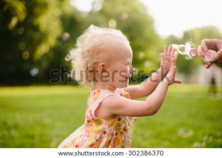 Little girl playing with bubbles