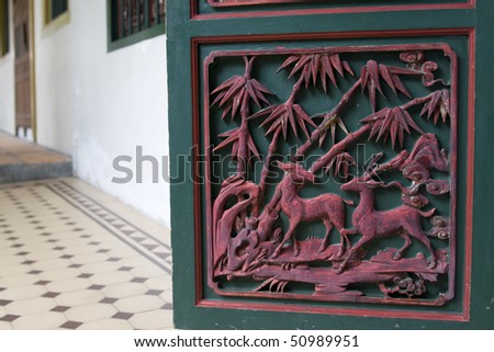close-up image of orient door with animal and flowers carvings on it.