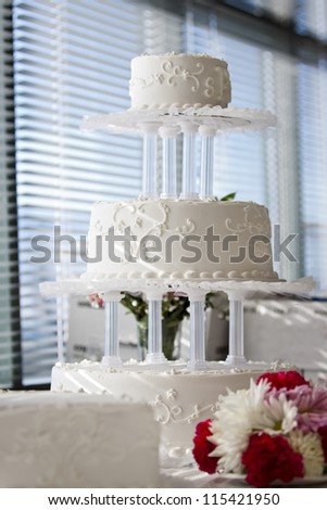 tree  level white wedding cake on table with flowers