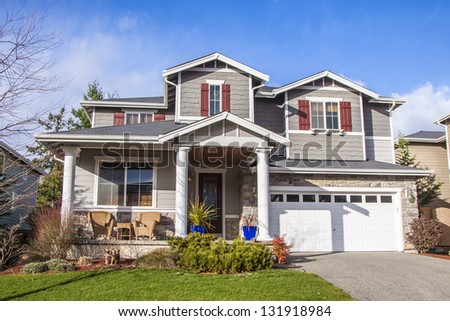 luxury family house with landscaping on the front and blue sky on background