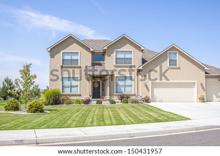 perfectly manicured suburban house on a beautiful sunny day