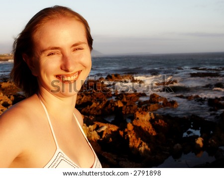 Beautiful blonde woman smiling on holiday by the ocean in South Africa.
