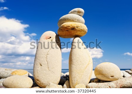 Pebble in balance between the two boulders against the cloudy sky