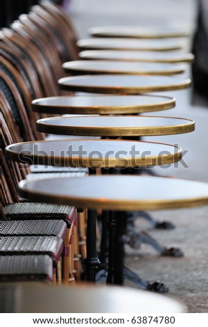 Several round tables in the  typical cafe in Paris. Photo with tilt-shift effect