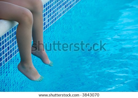 feet refreshing in swimming pool in summer