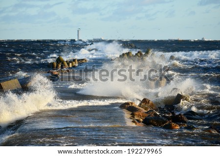 Big and powerful sea waves and a lighthouse during the storm
