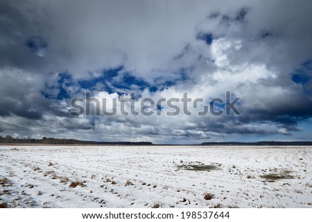Heavy snow storm clouds over fields in countryside