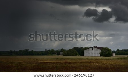 Tornado storm clouds above the shed in the countryside