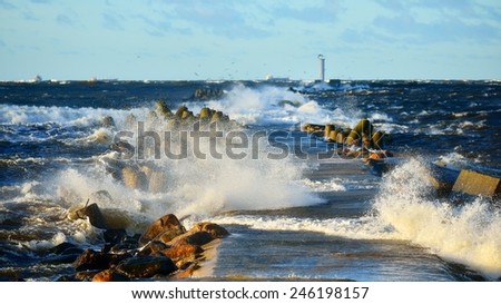 Big and powerful sea waves and a lighthouse during the storm