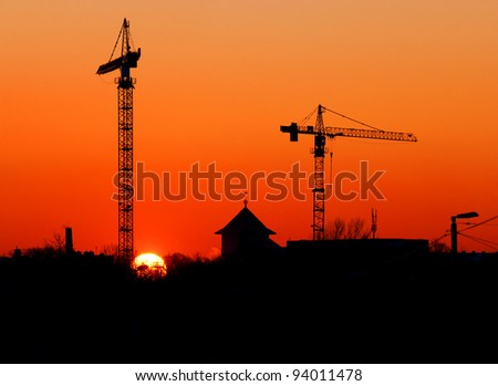 crane and other buildings silhouettes at the sunset