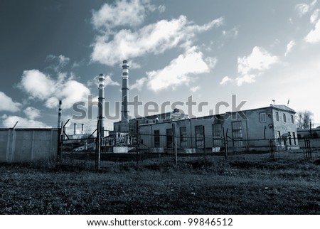 industrial factory producing electricity with pipes against blue sky