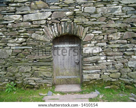 Stone wall with archway and oak door