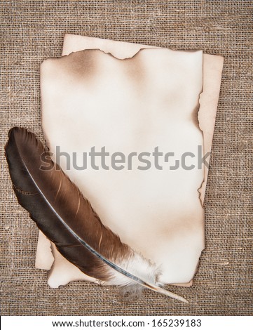 Aged paper with feather on sacking background