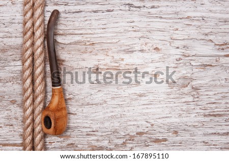 Rope and tobacco pipe on the old wood