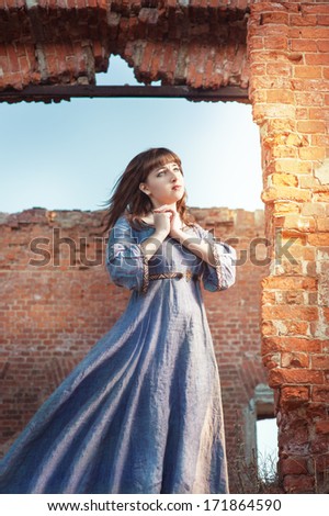 Young beautiful woman in medieval dress praying