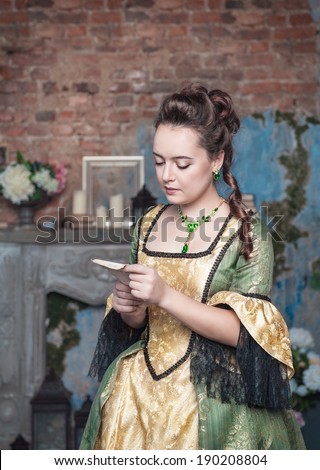 Beautiful woman in medieval dress reading letter