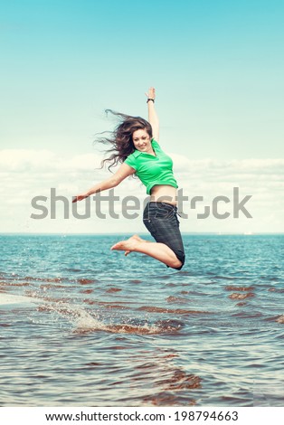 Happy woman jumping in the water of sea