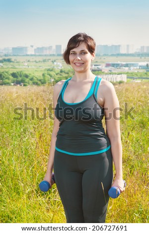Beautiful plus size woman exercising with dumbbells