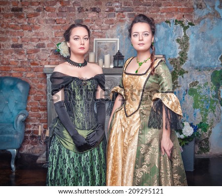 Two young beautiful women in long medieval dresses