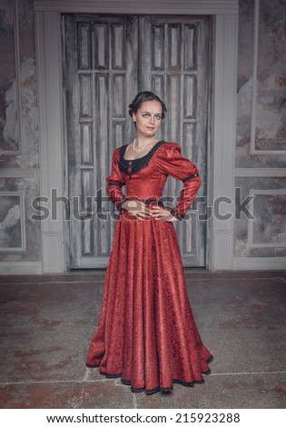 Beautiful young woman in red long medieval dress