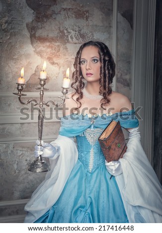 Beautiful woman in medieval dress with candelabrum
