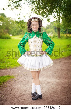 Young beautiful girl in irish dance dress and wig posing