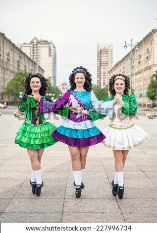 Three women in irish dance dresses and wig posing